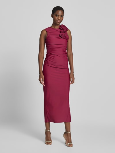 Frauenmodel trägt Cocktailkleid mit floralen Applikationen Modell 'DONA' von YAS in Körpernaher Passform aus bordeauxfarbenem Satin, Ganzkörperansicht von vorne.