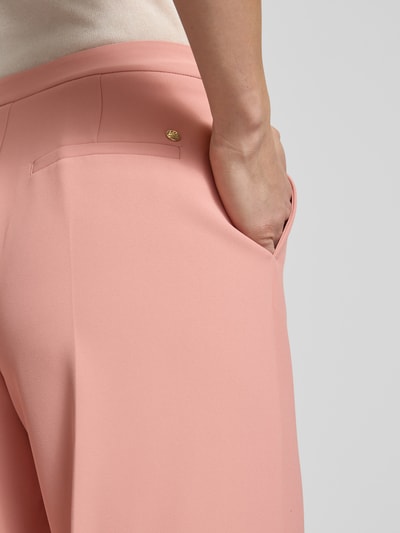 Frauenmodel trägt Hose mit Gesäßtaschen Modell 'Leya Miley' von MOS MOSH in zartem Rosa, feine Struktur, Detailaufnahme Gesäßtasche. Damen HOSE, Bügelfalten, Weites Bein, Bundweite 37 cm, Innenbeinlänge 77 cm, Größe 36.