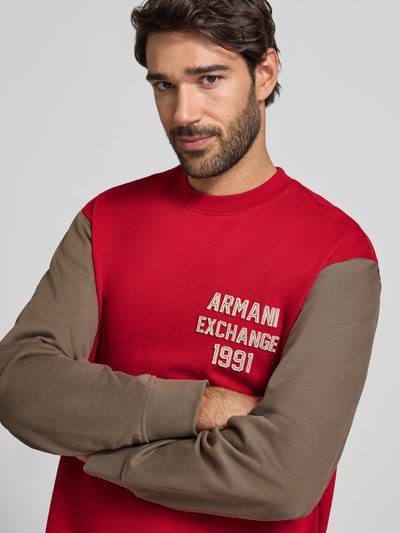Männermodel trägt Sweatshirt mit Label-Stitching und Rundhalsausschnitt von Armani Exchange, reine Baumwolle, krój regular fit, Nahaufnahme Oberkörper.