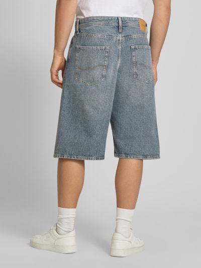 Męski model nosi Extra Baggy Fit Bermudas model 'IRON' od Jack & Jones, niebieska bawełna, wpuszczane kieszenie, szerokość w rozmiarze M: 45 cm, długość wewnętrzna nogawki w rozmiarze M: 31 cm, widok całej sylwetki z tyłu.
