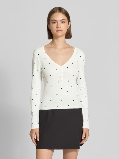 Frauenmodel trägt Regular Fit Langarmshirt aus Baumwoll-Mix Modell 'FENJA' von ONLY, weiß mit schwarzen Punkten, Ganzkörperansicht von vorne, Damen Langarmshirt von ONLY.