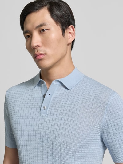 Männermodel trägt Slim Fit Poloshirt in Strick-Optik Modell 'Vanceo' von JOOP! Collection aus reiner Baumwolle, Nahaufnahme Oberkörper.