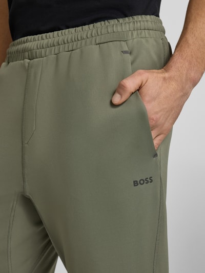 Mannenmodel draagt Regular Fit Sweatpants uit snel drogend materiaal Model 'HICON ACTIVE' van BOSS Green, look: effen, labelprint, elastische boord, flatlock-naden, zij-steekzakken, achterzak, detailopname bovenbeen.