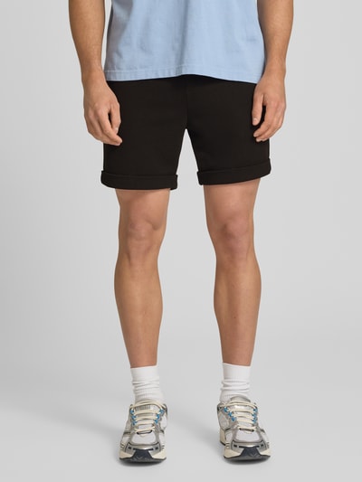 Männermodel trägt Regular Fit Shorts mit Viskose-Anteil Modell 'NEWKODYL' von Only & Sons in Melange-Optik mit Nadelstreifen-Muster, Eingrifftaschen, Gesäßtasche, elastischem Bundabschluss mit Tunnelzug und fixiertem Beinumschlag, Ganzkörperansicht von vorne.