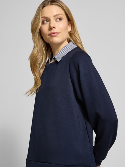 Frauenmodel trägt Sweatshirt mit gerippten Abschlüssen Modell 'BANU' von Soyaconcept in Dunkelblau mit Hemdblusenkragen, Nahaufnahme Oberkörper.
