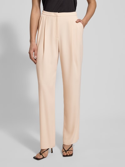 Frauenmodel trägt Stoffhose mit Bundfalten von Emporio Armani in Beige, lockerer Schnitt, französische Eingrifftaschen, Nahaufnahme Oberkörper.