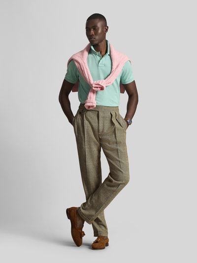 Männermodel trägt Regular Fit Poloshirt aus reiner Baumwolle von Polo Ralph Lauren in Mintgrün, unifarben, kurzarm, Logo-Detail, Ganzkörperansicht von vorne.