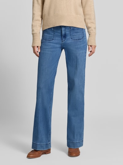 Frauenmodel trägt Wide Fit Jeans mit Eingrifftaschen von Christian Berg Woman in mittelblauer Farbe, Ganzkörperansicht von vorne. Man sieht Gürtelschlaufen, Knopf- und Reißverschluss, sichtbare Eingrifftaschen, bequeme Passform; Bundweite bei Größe 36/32: 36 cm, Innenbeinlänge: 78 cm.