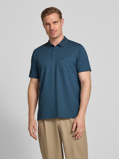 Männermodel trägt Regular Fit Poloshirt mit Knopfleiste und Brusttasche von RAGMAN aus Baumwoll-Mix, Herren, Ganzkörperansicht von vorne. Rückenlänge bei Größe M: 70 cm. Das Shirt ist in einem gedeckten Blauton, die Hose in Beige gehalten; glatte, strukturierte Materialien, klare Linien.