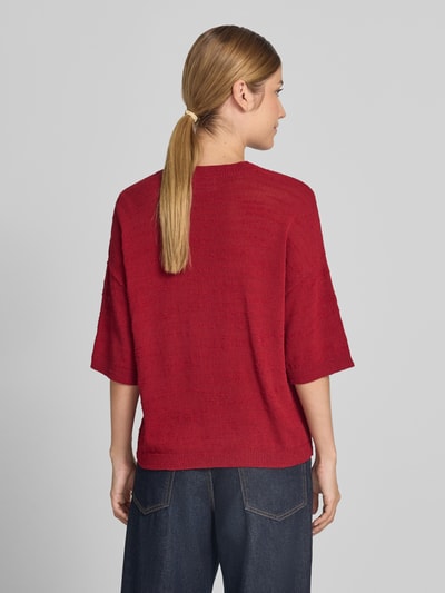 Vrouwenmodel draagt gebreid shirt met 1/2-mouwen Model 'Lauralynn' van MSCH Copenhagen, rood, mix van biologisch katoen, loose fit, ruglengte 53 cm bij maat S/M, mouwlengte 22 cm, ronde hals, schouderpartijen, Ganzkörperansicht Rückansicht.