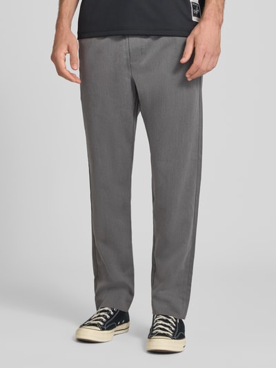 Männermodel trägt Relaxed Fit Hose mit elastischem Bund Modell 'TOBY' von JACK & JONES in Grau, Material-Mix, Ganzkörperansicht von vorne.