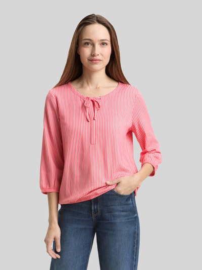 Frauenmodel trägt Regular Fit T-Shirt aus Baumwoll-Mix von Tom Tailor, rosa-weiß gestreift, V-Ausschnitt, Feinripp, Ganzkörperansicht von vorne.