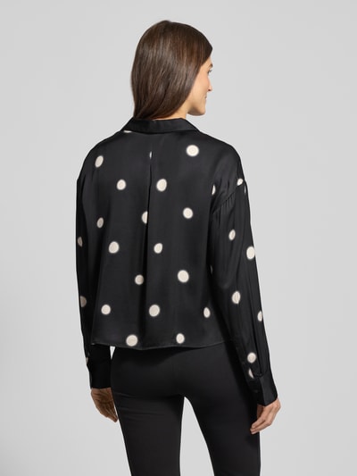 Vrouwenmodel draagt zwarte overhemdblouse met witte stippen van viscose, los model, overhemkraag en knoopsluiting Model 'Famena' van Opus, ruglengte 56 cm, mouwlengte 56 cm, Ganzkörperansicht Rückansicht.