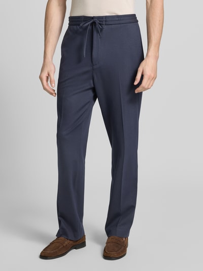 Männermodel trägt Regular Fit Stoffhose aus Viskose-Mix Modell 'ISCOVE' von Tiger Of Sweden, Dunkelblau, Tunnelzug, Bundfalten, Ganzkörperansicht von vorne. Kontext: Herren Stoffhose, Bundweite bei Größe 50: 42 cm, Innenbeinlänge bei Größe 50: 82 cm.