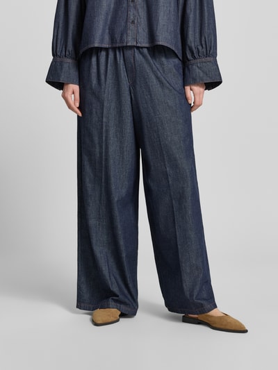 Frauenmodel trägt Wide Leg Jeans mit elastischem Bund Modell 'CEILING' von Drykorn aus Reine Baumwolle in dunkler Jeans-Optik, Nahaufnahme Unterkörper.