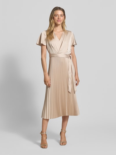 Frauenmodel trägt Midikleid mit Plisseefalten und V-Ausschnitt von comma, taillierter Schnitt, Bindegürtel, beige, Ganzkörperansicht von vorne.