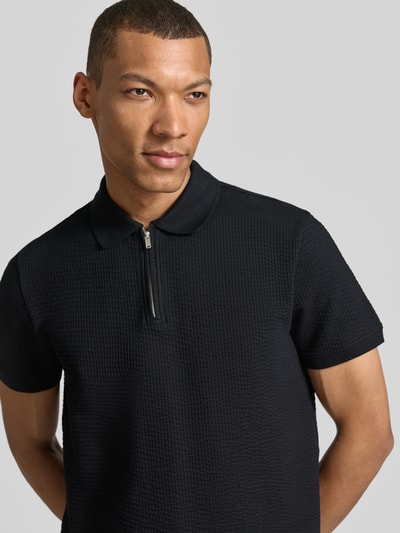 Männermodel trägt Regular Fit Poloshirt mit Strukturmuster von MCNEAL in Schwarz, Reißverschluss, Baumwoll-Mix, Kurzärmelig, Nahaufnahme Oberkörper.