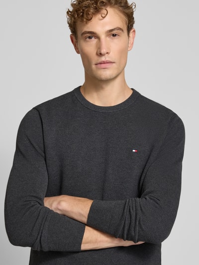 Mężczyzna model nosi Regular Fit Pullover aus reiner Baumwolle von Tommy Hilfiger, ciemnoszary, drobna faktura, Nahaufnahme Oberkörper.