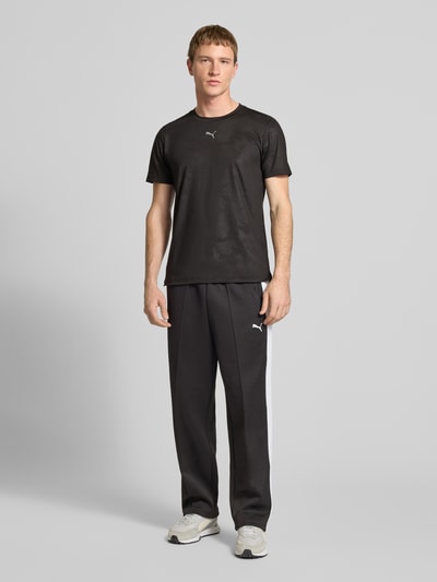 Männermodel trägt Herren T-Shirt mit Label-Detail Modell 'CLOUDSPUN' von PUMA PERFORMANCE, Schwarz, Elastischer-Material-Mix, Gerader-Schnitt, Rundhalsausschnitt; Rückenlänge bei Größe M 63 cm, Ganzkörperansicht von vorne.