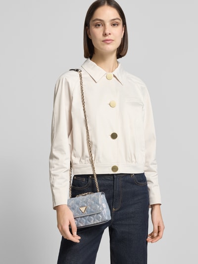 Kobiece modelka nosi Shoulder Bag mit Logo-Applikation Modell 'Giully' od Guess w niebieskim kolorze, stepp-optyka, detal z łańcuszkiem, widok na górną część ciała z przodu, szerokość w rozmiarze 17 cm, długość 14 cm, głębokość 6 cm, długość paska na ramię 120 cm, wnętrze z kieszenią na zamek, podział głównej komory, zamknięcie magnetyczne