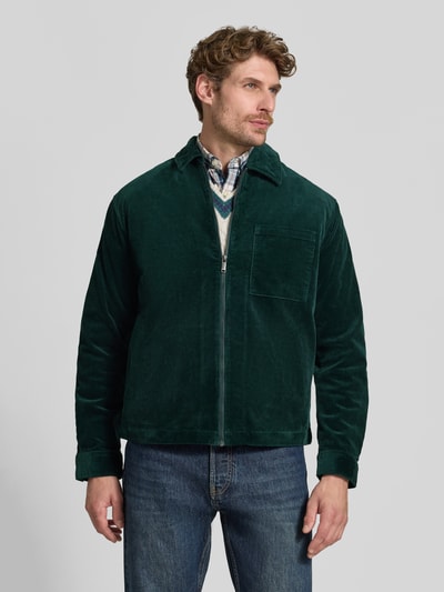 Männermodel trägt Regular Fit Hemdjacke aus Cord mit Brusttasche von MCNEAL in Dunkelgrün, Struktur sichtbar, Ganzkörperansicht von vorne. Baumwoll-Elasthan-Mix, Kentkragen, Reißverschluss, Rückenlänge Größe M 70 cm.