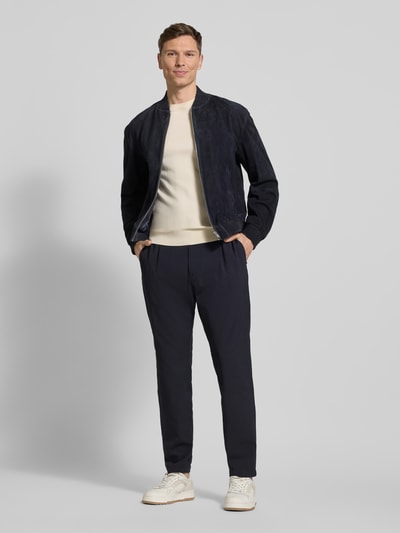 Mężczyzna nosi Slim Fit Stoffhose mit Strukturmuster von CRUNA, elastyczna mieszanka materiałów, krój slim fit, fakturowany wzór, kieszenie z tyłu, elastyczny pas, wpuszczane kieszenie, szerokość w rozmiarze 50: 44 cm, długość wewnętrzna nogawki w rozmiarze 50: 79 cm, widok całej sylwetki z przodu.