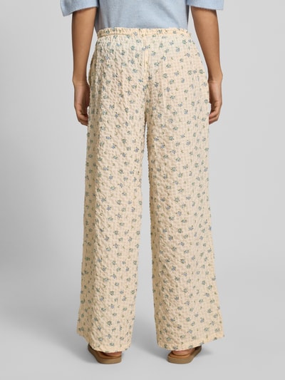 Frauenmodel trägt Wide Leg Pull-on-Hose aus Seersucker mit Kordelzug von REVIEW im Elastischer-Material-Mix mit dezentem Blumenmuster, Ganzkörperansicht Rückansicht. Bundweite bei Größe S: 97 cm, Innenbeinlänge bei Größe S: 67 cm.
