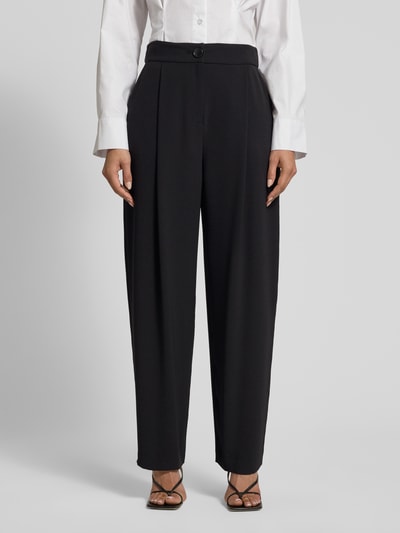 Frauenmodel trägt Relaxed Fit Hose mit Bundfalten von ARMANI EXCHANGE in Schwarz, gerade Form, glatte Textur, Nahaufnahme Oberkörper. Bundfalten, Eingrifftaschen, Knopf- und Reißverschluss, Bundweite 38 cm, Innenbeinlänge 76 cm bei Größe 36.