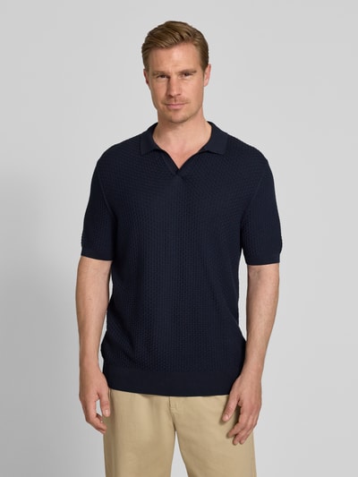 Męski model nosi Regular Fit Poloshirt aus reiner Baumwolle Modell 'NATALO' von BOSS w kolorze granatowym, tekstura pikowana, gładki wzór, kołnierzyk polo, krój regular fit, krótki rękaw, bawełna, zdjęcie całej sylwetki z przodu.