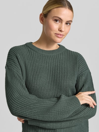 Vrouwenmodel draagt Regular Fit pullover met crew neck model 'LEA' van VERO MODA in donkergroen grof gebreid, Nahaufnahme Oberkörper.