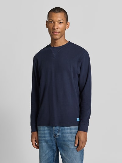 Männermodel trägt Regular Fit Sweatshirt aus reiner Baumwolle von Scotch & Soda in Dunkelblau, Strukturmuster, Nahaufnahme Oberkörper.