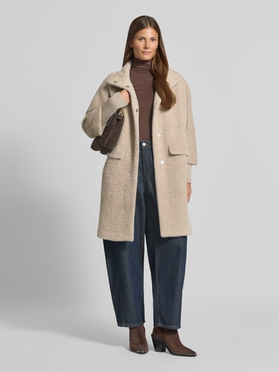 Kobiece modelka nosi Relaxed Fit płaszcz z fakturowanym wzorem od COMMA, jasnobeżowy, stójka, wpuszczane kieszenie, elastyczne zakończenia rękawów, długość tyłu w rozmiarze 36: 98 cm, szerokość ramion: 40 cm, szerokość w klatce piersiowej: 57 cm, długość rękawów: 49 cm, widok całej sylwetki od przodu.