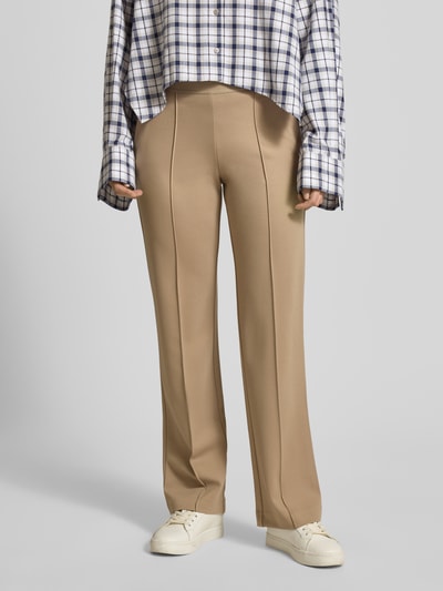 Frauenmodel trägt Stoffhose mit elastischem Bund von Christian Berg Woman, lockerer Schnitt, Bundfalten, französische Eingrifftaschen, Gesäßtaschen, Innenbeinlänge 89 cm, Bundweite 36 cm, Beige, Ganzkörperansicht von vorne.