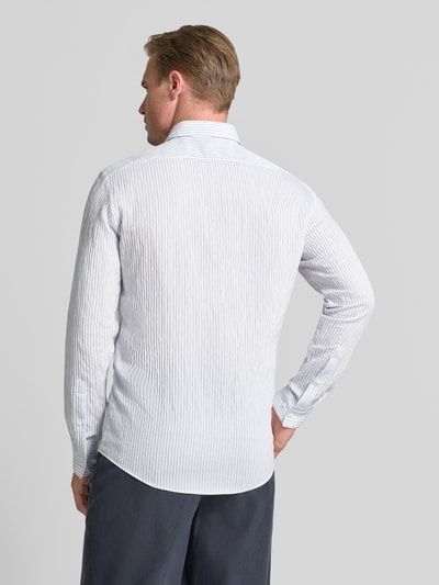 Männermodel trägt helles Modern Fit Businesshemd aus Viskose-Mix Modell 'VALERIO' von HUGO mit feinen Streifen, Ganzkörperansicht Rückansicht. Herren Businesshemd von HUGO.