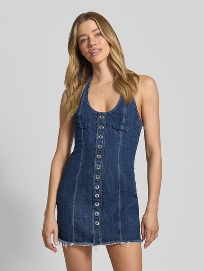 Frauenmodel trägt Mini-Jeanskleid aus reiner Baumwolle Modell 'LONCIA' von MAX&Co., Denim-Optik, enge Passform, Mini-Länge, Kontrast-Nähte, Destroyed-Details, Reißverschluss, Neckholder, Ganzkörperansicht von vorne.