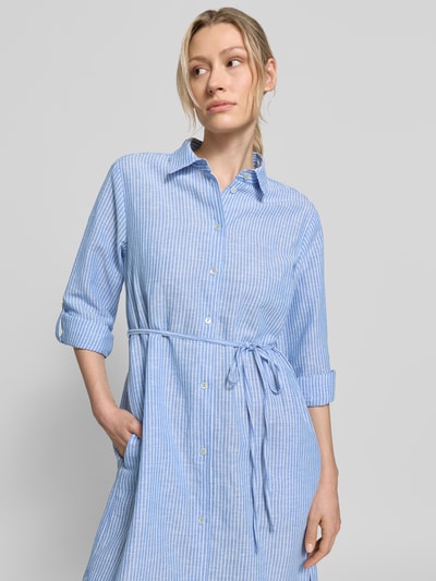 Vrouwenmodel draagt 'Midikleid aus reinem Leinen in langärmeligem Design' van Christian Berg Woman in blauw met wit, zuiver linnen, getailleerde pasvorm, overhemdblouselook, platte kraag, met lange mouwen, afneembare stoffen band en doorlopende knoopsluiting, ruglengte maat 36: 122 cm, borstwijdte maat 36: 52 cm, mouwlengte maat 36: 64 cm. Nahaufnahme bovenlichaam.