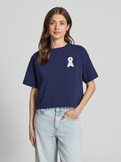 Vrouwenmodel draagt Loose Fit T-Shirt uit pure biologische katoen model 'ALBERTARAA' van Armedangels, uni donkerblauw, logo-stitching, regular fit, cropped lengte, ronde hals, korte mouw, jerseystructuur, pure katoen, volledige vooraanzicht bovenlichaam.