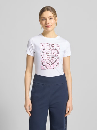 Frauenmodel trägt Regular Fit T-Shirt aus reiner Baumwolle von Tom Tailor Denim, Mehrfarbig, Gestreift, Label-Stitching-Applikation, Rundhals-Ausschnitt, Kurzarm, Jersey, Ganzkörperansicht von vorne.