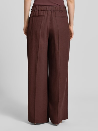 Frauenmodel trägt Relaxed Fit Hose aus Leinen-Mix Modell 'TIANA11' von BOSS, Optik: Unifarben, Material: Leinen-Viskose-Mix, Bügelfalten, elastischer Bundabschluss, seitliche Eingrifftaschen, Paspeltaschen hinten, Ganzkörperansicht Rückansicht.