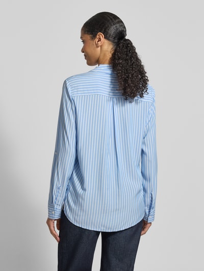 Frauenmodel trägt Comfort Fit Hemdbluse aus reiner Viskose von s.Oliver RED LABEL in Hellblau mit weißen Streifen, Rückenpasse und Kellerfalte, Ganzkörperansicht Rückansicht.