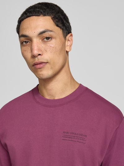Männermodel trägt Relaxed Fit T-Shirt aus reiner Baumwolle von Marc O'Polo DENIM in Lila, glatte Textur, Nahaufnahme Oberkörper.