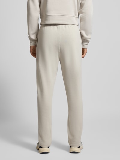 Mężczyzna nosi Straight Fit Sweatpants mit Label-Stitching von CHAMPION z mieszanki bawełny, jasny kolor, pas elastyczny, ganzkörperansicht rückansicht.