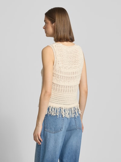 Frauenmodel trägt Regular Fit Weste aus Baumwoll-Mix Modell 'ALIX' von Only in Strickoptik mit Fransen, cremefarben, Ganzkörperansicht Rückansicht.