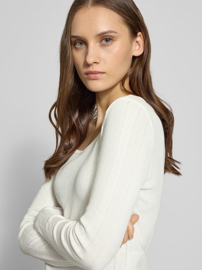 Vrouwenmodel draagt Slim Fit Langarmshirt uit bio-katoenmengsel model 'TENNA LIFE' van ONLY, fijn ajourpatroon, unikleuren, bootshals, fijne brei, frill aan mouwen en zoom. Close-up van bovenlichaam.