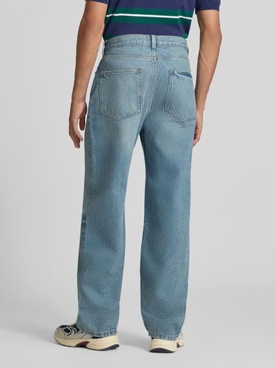 Männermodel trägt Baggy Fit Jeans mit Knopfverschluss von REVIEW aus reiner Baumwolle, 5-Pocket-Design, mittelblau, Ganzkörperansicht Rückansicht.