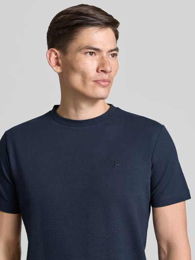 Männermodel trägt T-Shirt mit Strukturmuster und Logo-Stitching von Lerros in Dunkelblau, Baumwoll-Mix mit Stretch-Anteil, Regular-Fit, Rundhalsausschnitt, Nahaufnahme Oberkörper.