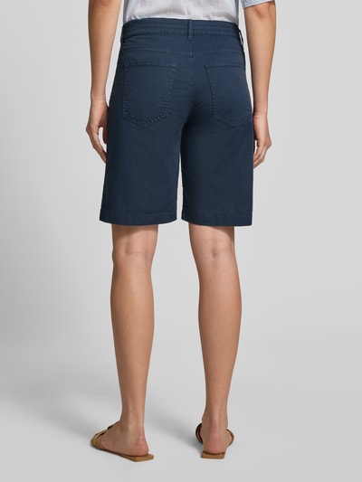 Vrouwenmodel draagt Regular Fit Bermuda uit katoenmix model 'MAINE B' van Brax, look: effen, met 5-pocketmodel en riemlussen, sluiting: knoop met verborgen ritssluiting, kleur donkerblauw, geheel achteraanzicht.