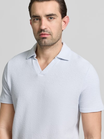 Męski model nosi Regular Fit Poloshirt aus Baumwoll-Mix von MCNEAL, jasnoniebieska faktura waffle-piqué, krótki rękaw, widok na górną część ciała z przodu.