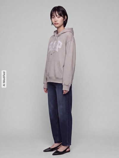 Kobieta modelka ma na sobie bluzę Regular Fit Sweatshirt aus Baumwoll-Mix model 'HERITAGE PO' od GAP, szaro-beżowy kolor, prosta forma, gładka tekstura, damska bluza GAP, widok całej sylwetki z przodu, KI-modifiziertes Bild