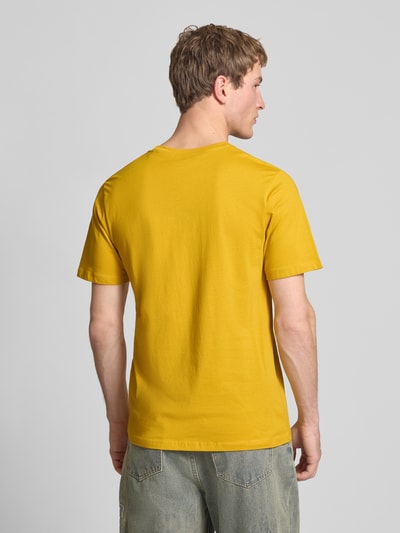 Męski model nosi Regular Fit T-Shirt aus reiner Baumwolle Modell 'EGGO' od Pepe Jeans, jednolity żółty kolor, krój regular fit, okrągły dekolt, krótki rękaw, materiał jersey z czystej bawełny, widok całej sylwetki z tyłu.